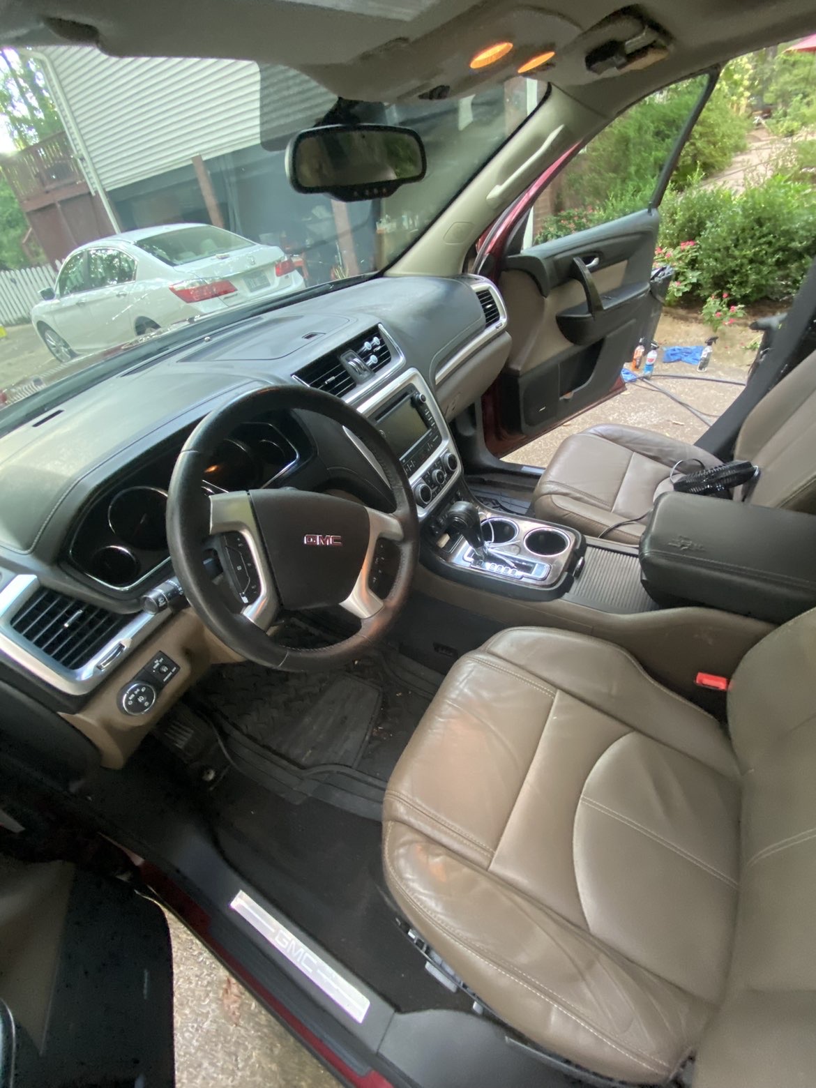 Freshly detailed GMC Acadia front interior with clean dash, console and leather seats